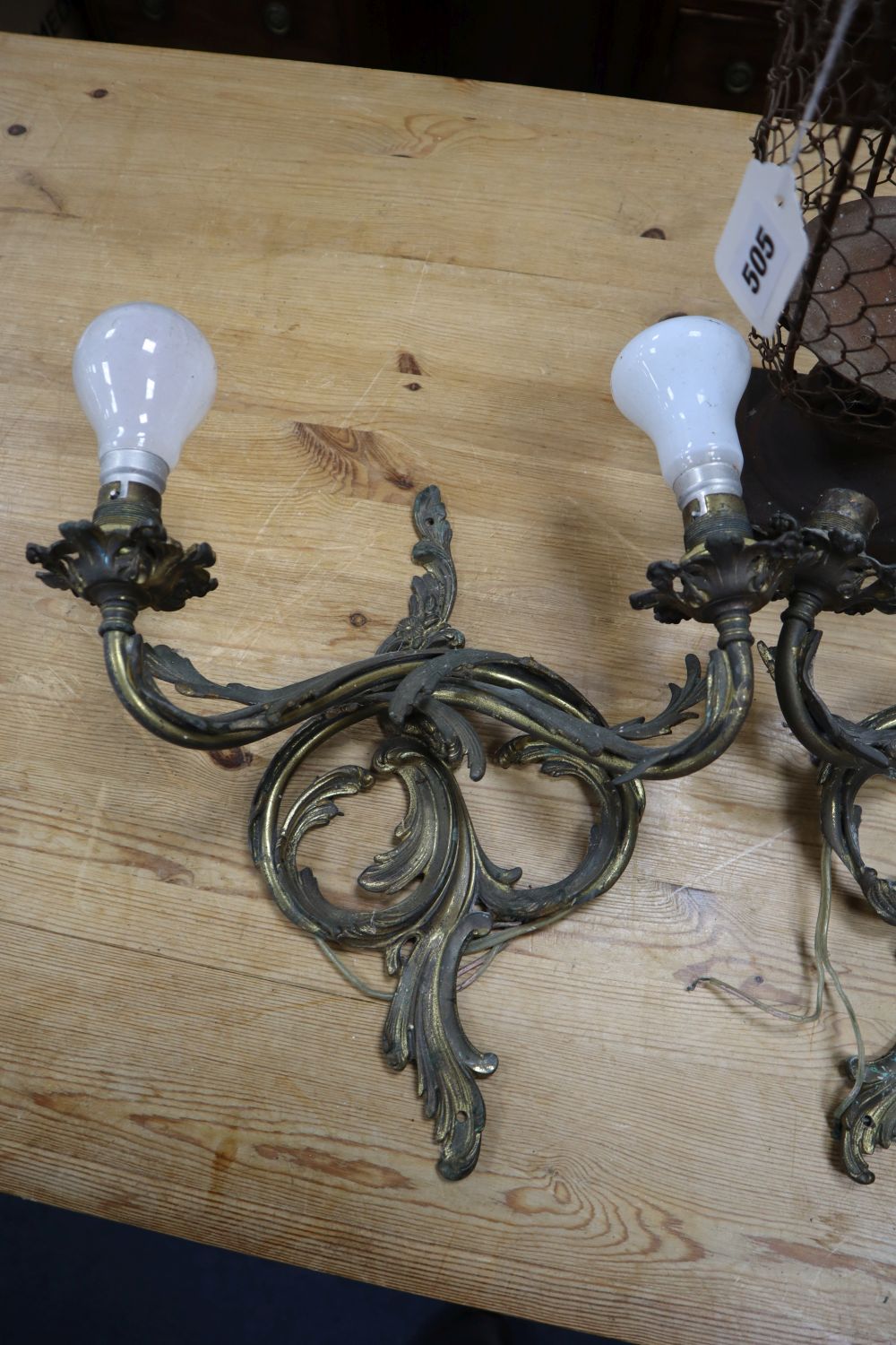 A pair of Louis XV style gilt metal two branch wall lights, and a metal wire framed pricket candle holder, 33cm